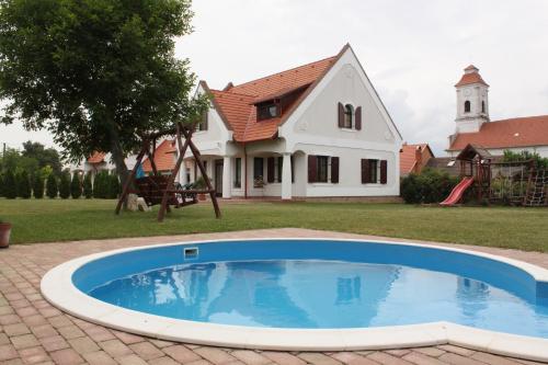 大瓦若尼Hétkanyar Vendégház的房屋前有游泳池的房子