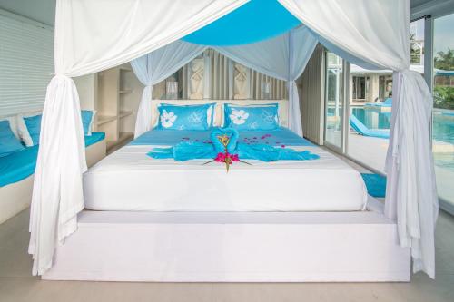 吉利特拉旺安巴厘岛海滩吉利别墅的一间卧室配有一张带天蓬的床
