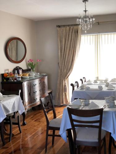 戈尔韦斯莱纳马拉住宿加早餐旅馆的一间带桌椅和镜子的用餐室