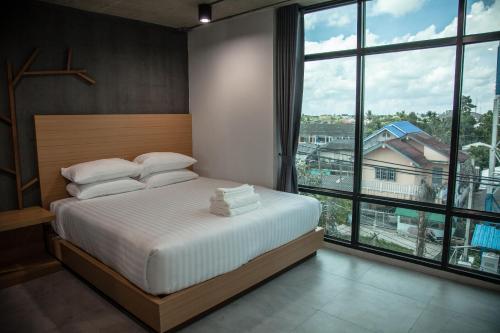 洛坤府M1 Hotel的一间卧室设有一张床和一个大窗户