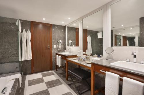 里约热内卢Windsor Marapendi Hotel的一间带两个盥洗盆和大镜子的浴室