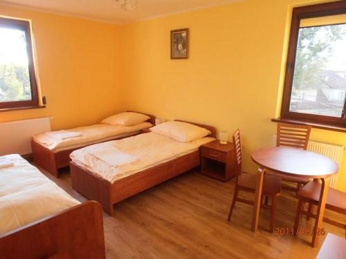 克拉科夫拉吉夫尼基大道酒店的客房设有两张床、一张桌子和一张桌子以及椅子。