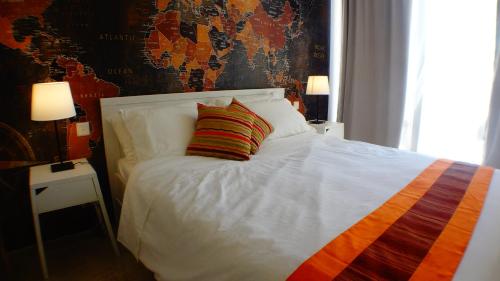 马萨尔福恩R1103ERI by euroresort的一张白色的床,上面有彩色条纹枕头