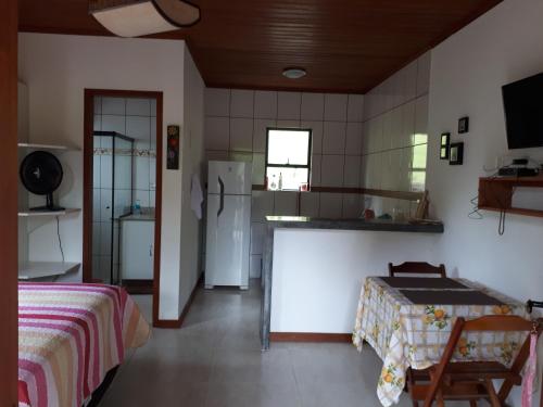 圣佩德罗塞拉Chalé em São Pedro da Serra - Nova Friburgo的带冰箱的厨房和客房内的一张床