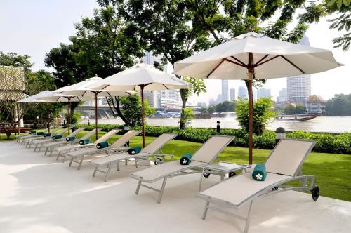 曼谷宜必思曼谷河畔酒店的一把带遮阳伞的躺椅