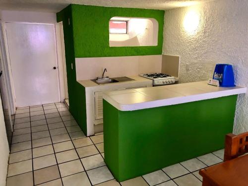 曼萨尼约Suites Santa Barbara的绿色白色的厨房设有水槽和炉灶