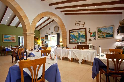 波多佩特罗娜玛蒂娜农庄酒店的餐厅配有白色桌椅和蓝色桌布