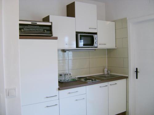 斯普利特Apartment Veronica的小厨房配有白色橱柜和微波炉