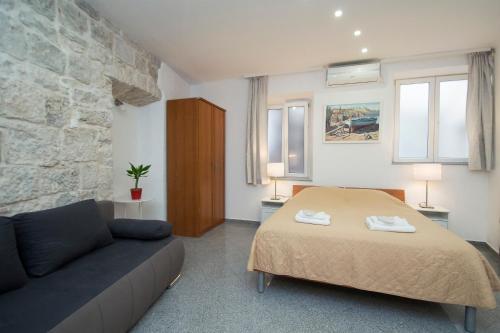 科尔丘拉Apartments Galerija的一间卧室配有一张床和一张沙发