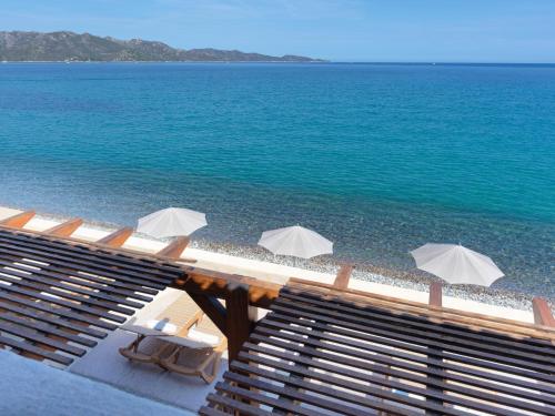 圣弗洛朗多尔奇诺特酒店的海滩上设有椅子和遮阳伞,还有大海