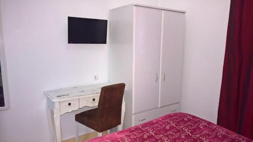 波塔莱格雷Casa Dom Manoel的一间卧室配有一张桌子、一把椅子和一个橱柜