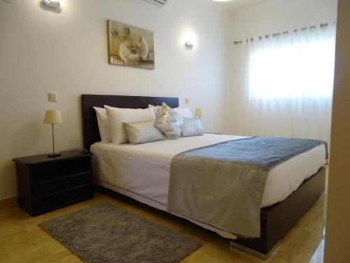 布尔高Casa Afonso Henriques的一间卧室配有一张带白色床单的床和一扇窗户。