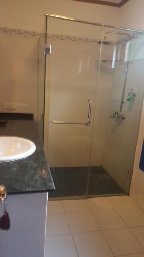 本托塔保格别墅酒店的一间带玻璃淋浴和水槽的浴室