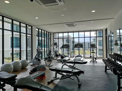 金宝草地公园民宿的一个带几台跑步机和健身自行车的健身房,位于带窗户的房间