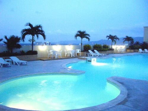 合艾Lee Gardens Plaza Hotel - SHA Plus的夜间蓝色海水的大型游泳池