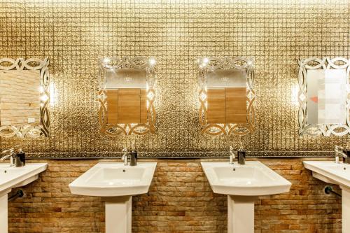坤敬画廊湖景酒店的配有3个盥洗盆和镜子的公共浴室