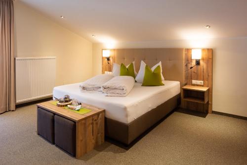 Sankt Veit in Defereggen阿尔彭加斯托夫皮希勒酒店的一间卧室配有一张带绿色枕头的大床