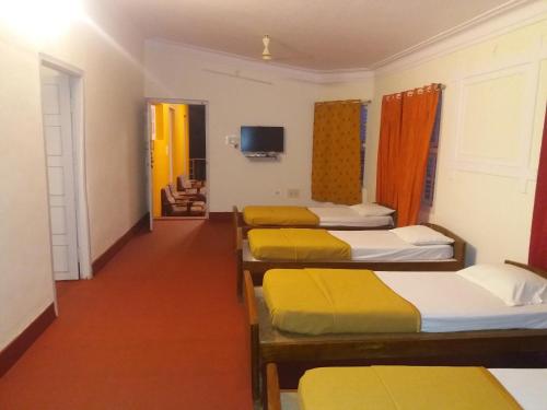 SrimangalaSherlock Jungle Retreat的一间设有四张床的客房和一个带电视的走廊