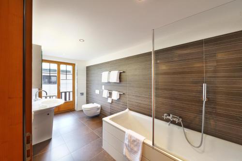 采尔马特加尼特斯特格里加酒店的带浴缸、卫生间和盥洗盆的浴室