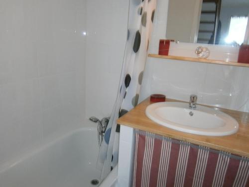卡尔萨克阿亚克La Chenillette的浴室配有盥洗盆和浴缸。