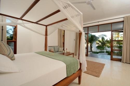 帕杰齐斯瓦海滩公寓的一间卧室配有一张带天蓬的白色床
