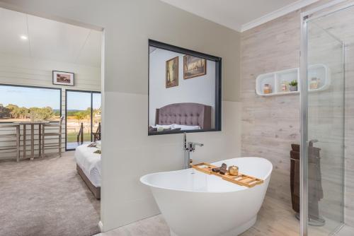 亨利布鲁克天鹅谷度假酒店的带浴缸的白色浴室和卧室