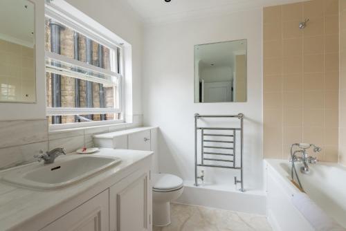 伦敦One bedroom High street kensington Apartment的浴室配有盥洗盆、卫生间和浴缸。