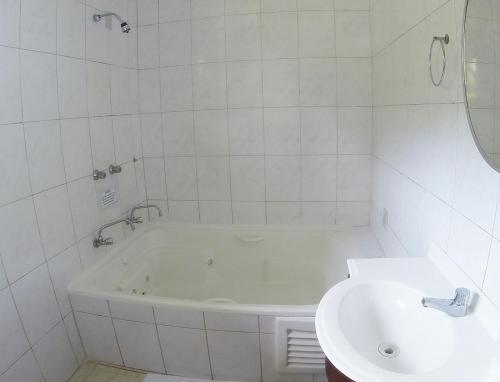 圣阿马鲁-达因佩拉特里斯Hotel Imperador Caldas的白色的浴室设有浴缸和水槽。