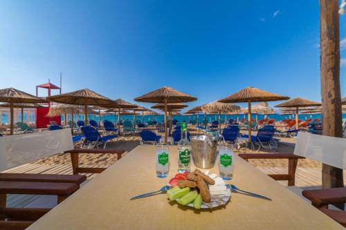 阿默达拉-伊拉克利翁Tropical Beach A的海滩上一张桌子和一盘食物