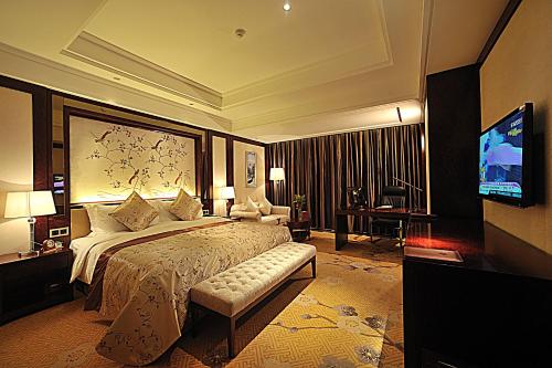 泰州泰州国际金陵大酒店的酒店客房,配有床和电视
