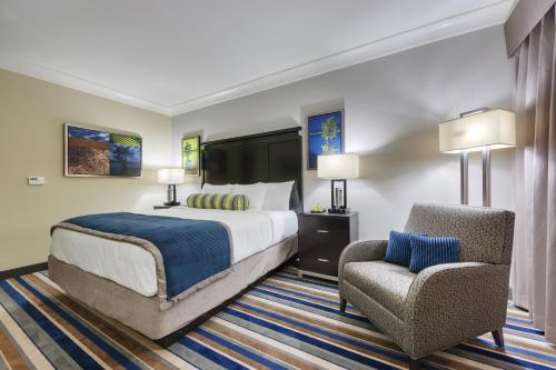 FranklinCypress Bayou Casino Hotel的配有一张床和一把椅子的酒店客房