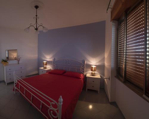 丽都玛里尼Appartamento Pesce的一间卧室配有红色的床和2个床头柜