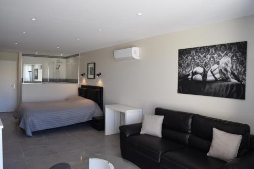 阿格德角HELIOPOLIS CAP D'AGDE VILLAGE NATURISTE的客厅配有沙发和1张床