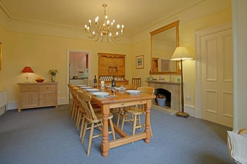 牛顿莫尔Netherwood House的一间带木桌和椅子的用餐室
