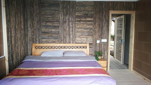 元阳县元阳路晟阳光客栈的一间卧室配有一张大床和木制床头板