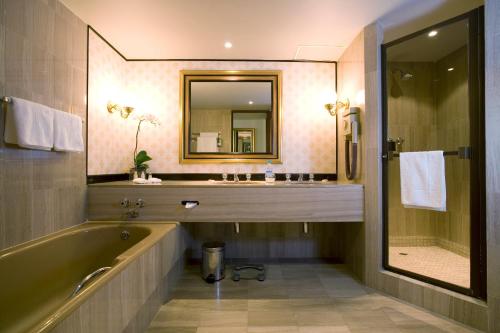 开普敦南太阳角酒店的带浴缸、水槽和镜子的浴室