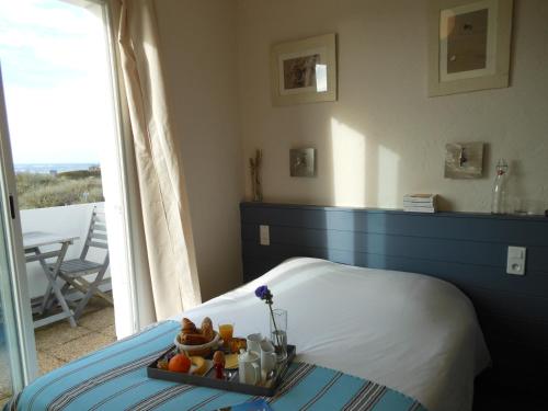 奥雷龙圣乔治小海滩酒店的一间卧室配有一张床,上面有水果盘
