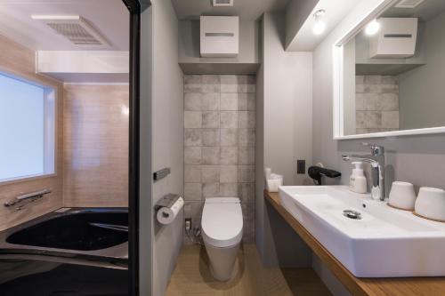 东京Hotel Vintage Tokyo的浴室配有盥洗盆、卫生间和浴缸。