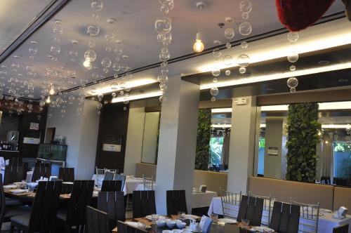 美岸拉匹拉酒店的用餐室配有桌椅和吊灯。