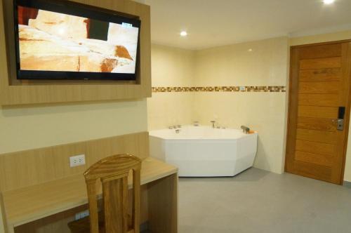 普卡尔帕Águila Dorada Selva Hotel的一间带水槽的浴室和墙上的电视