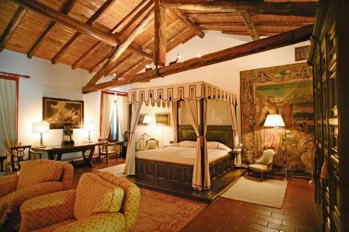 加尔达罗堪达圣维吉里奥酒店的一间卧室配有一张天蓬床和两把椅子