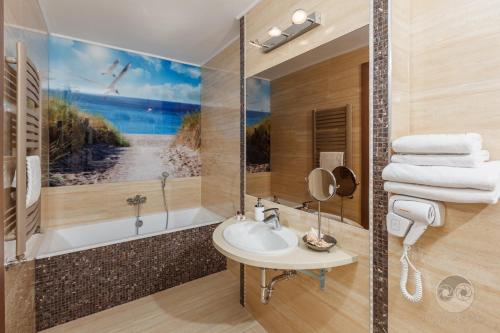 加茨比亚格拉Hotel SPA Activia的浴室配有盥洗盆和浴缸。