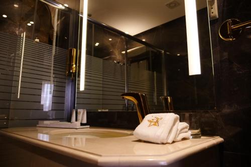 科威特Lumiere Des Etoile的浴室设有水槽、毛巾和镜子