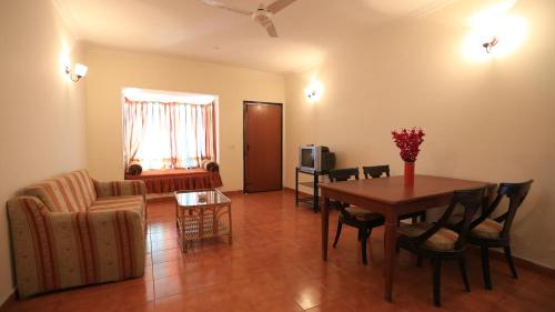拉尼凯特Woodsvilla Residency的客厅配有桌子和沙发