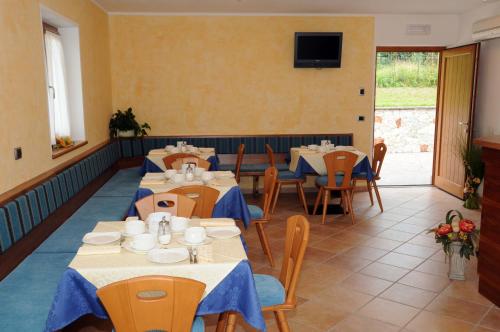 特伦托阿格例图维杜塔旅馆的一间带桌椅的餐厅以及墙上的电视