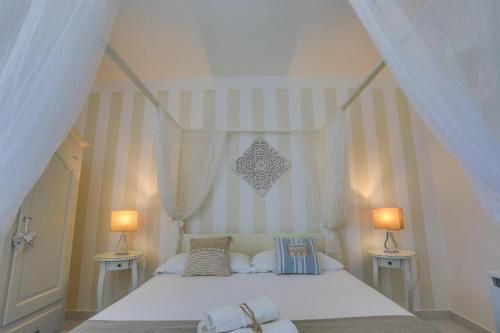 切萨雷奥港Il FARO的卧室配有带两盏灯的白色床