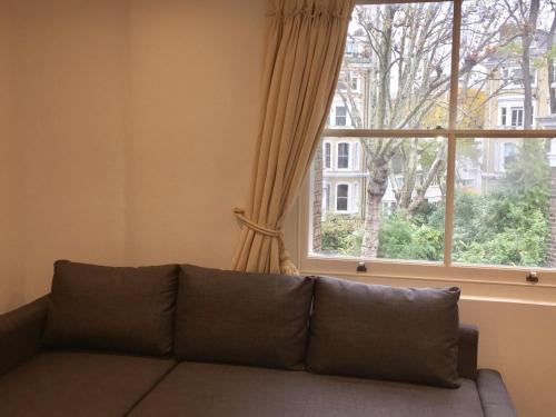 伦敦Lexham Gardens Lodge 5的客厅设有一张沙发,配有窗户