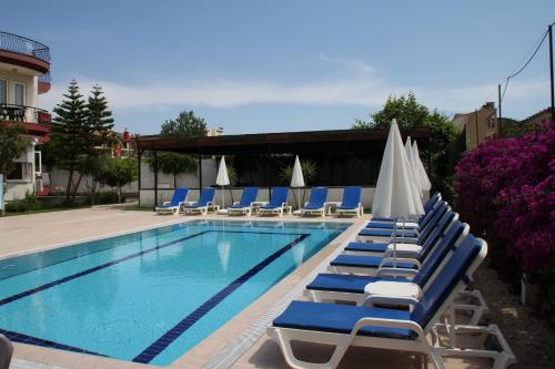 凯麦尔Minta Apart Hotel的一个带躺椅和遮阳伞的游泳池