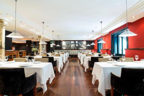 巴塞罗那1898酒店的一间设有白色桌椅的用餐室
