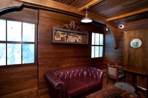 滨海韦斯顿卡伯特苑威瑟斯本酒店的配有木墙的客房内的真皮沙发
